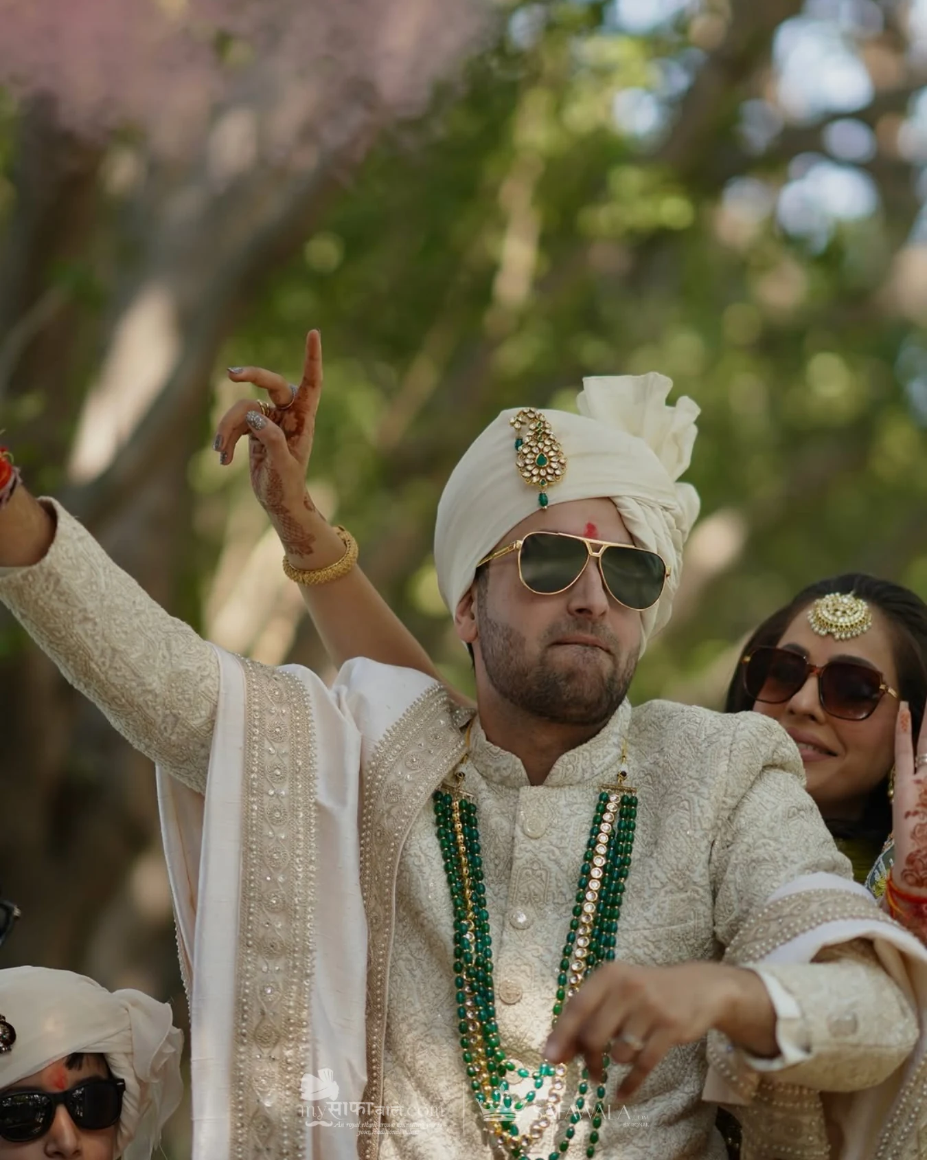 Groom in an ivory wedding safa with emerald jewellery for baraat safa tying in Lonavala